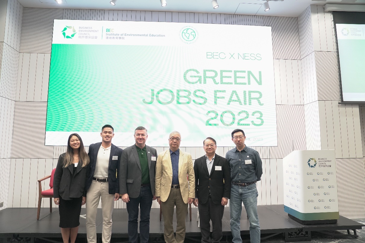 A group of people posing for a photo in front of a large screen

Description automatically generated with medium confidence