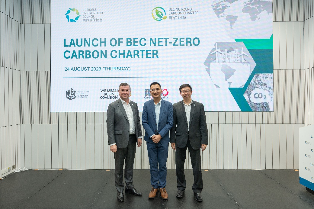 A group of men standing in front of a large screen

Description automatically generated
